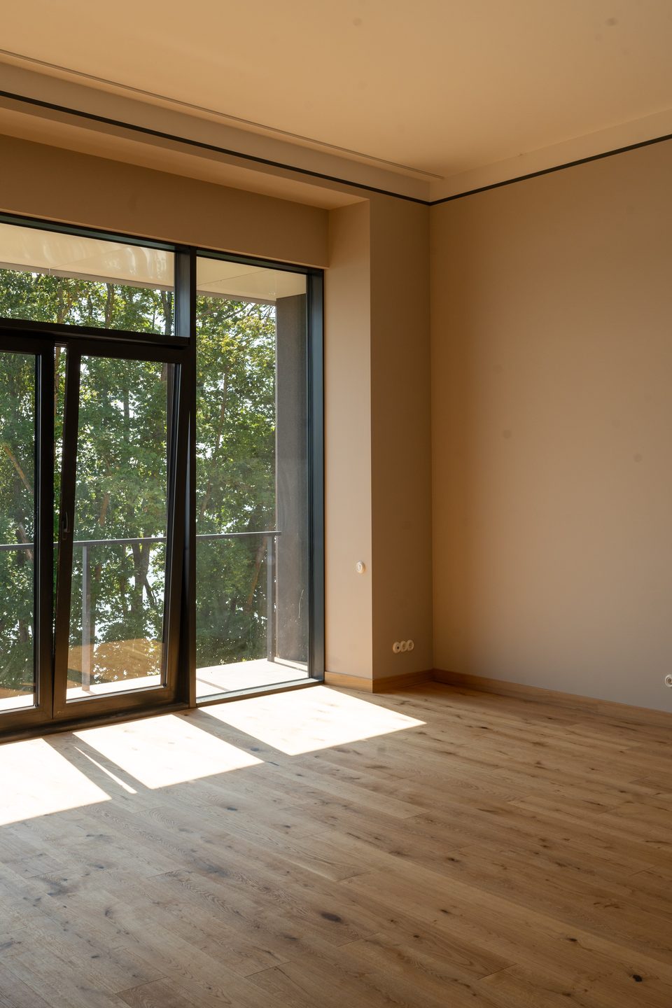 A new-build apartment in partial finish: plastered walls and a bare screed, before flooring and lighting